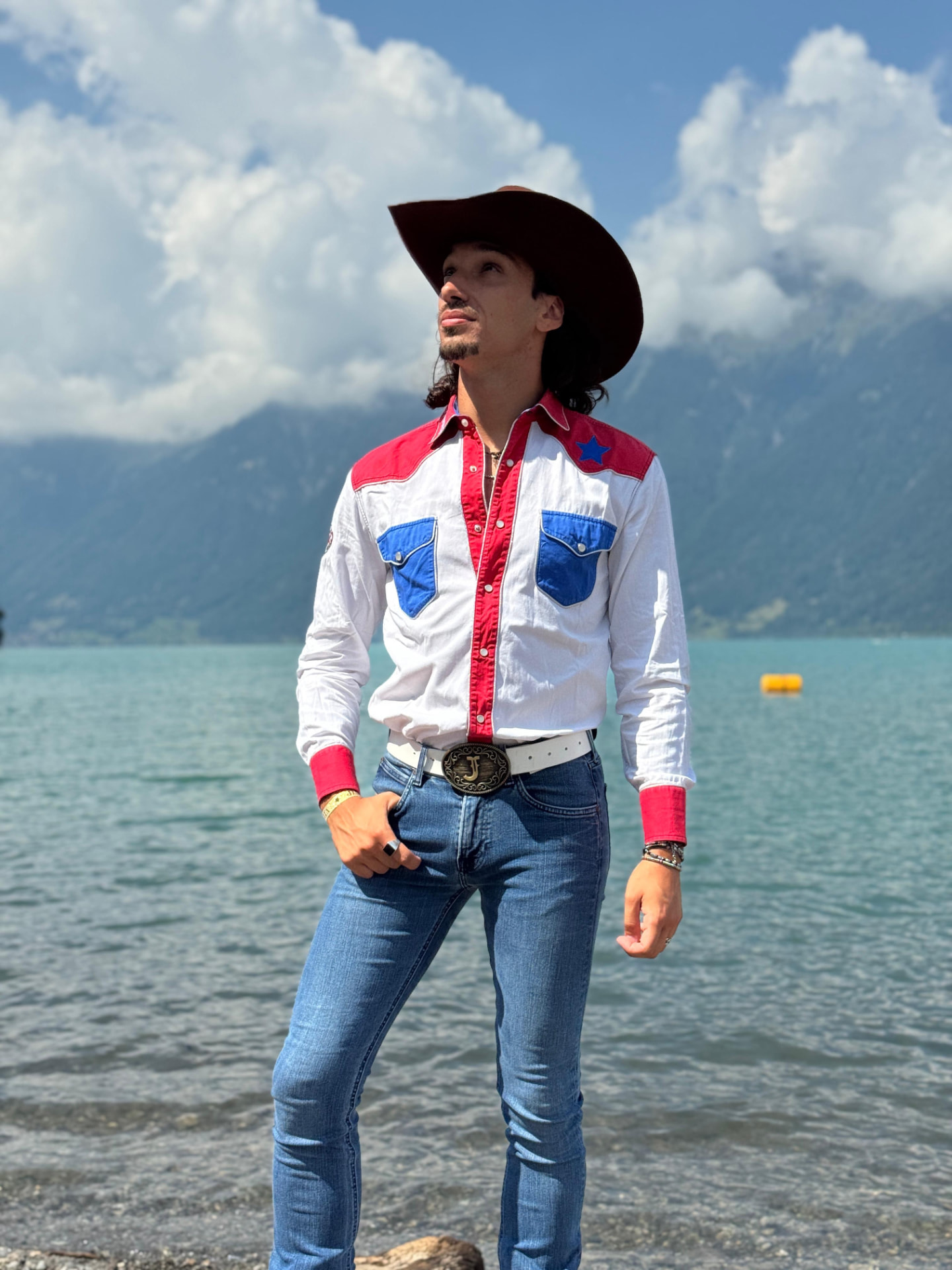 Johnny Rossato an einem Bergsee in einem rot-weiß-blauen Westernhemd